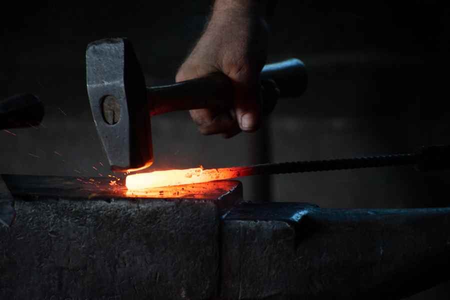 man hammering red hot metal