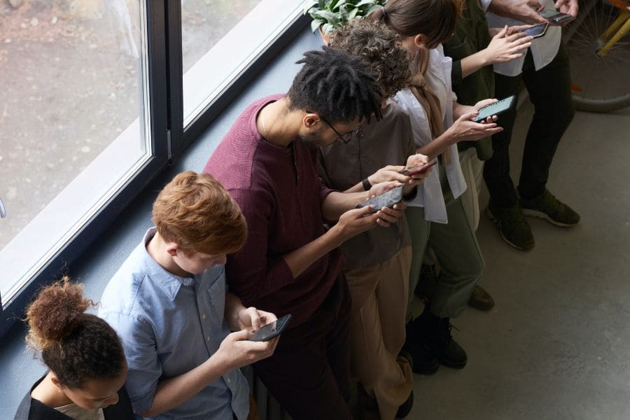 a line of people all looking at their phones